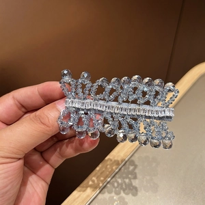 Detail of handcrafted blue crystal hair clip with woven beads and clear zircon stones