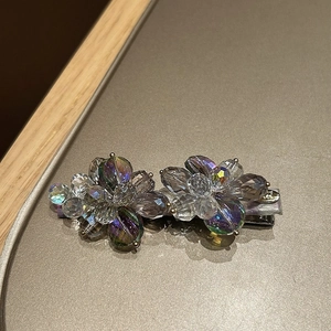 Detailed macro view of luxurious crystal flower hair clip with rhinestones and gold beads