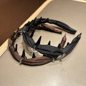 Close-up of pleated satin headbands with rhinestones and studs in black and dark brown