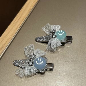 Dettaglio di fermagli per capelli con perle, fiocchi di pizzo e base in metallo strass