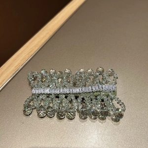 Macro detail of handmade green velvet hair clip with crystals and sparkling rhinestones