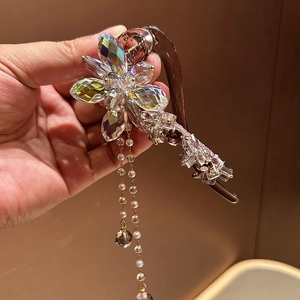 Détail d'une pince à fleurs en cristal avec glands de perles blanches en or champagne chic