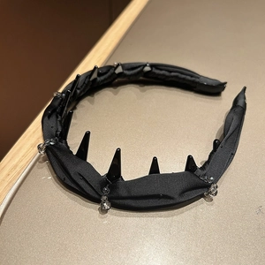 Detail view of black pleated satin headband featuring gothic spikes and bead embellishments