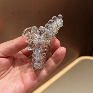 Gros plan d'une pince à cheveux en cristal avec des détails de fleurs en pierres tissées