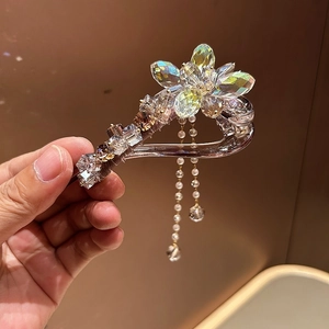Détail d'une pince à fleurs en cristal avec perles pendantes et pompons scintillants