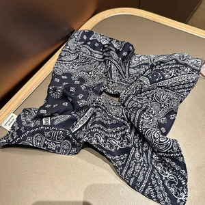 Close-up of navy blue paisley silk hair tie featuring a handmade label and soft texture