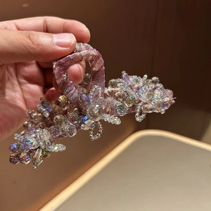 Détail de la grande pince à cheveux ornée de cristaux colorés et d'un tissu violet