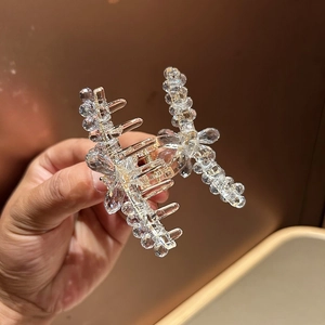 Vue détaillée du tissage en cristal irisé et de la pince à cheveux papillon