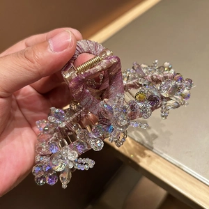 Détail d'une grande pince à cheveux fleurie en cristal rose avec texture soie brillante