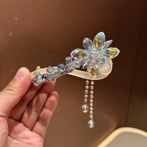 Détail de la pince à cheveux avec pétales en cristal irisé et glands de perles
