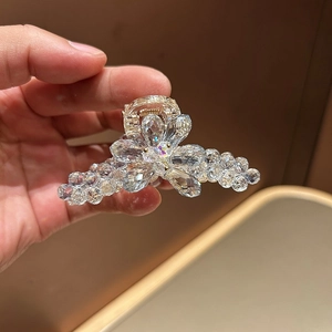 Vue détaillée des perles de cristal facettées et du clip en métal doré de l'accessoire