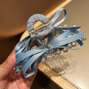 Detail view of elegant blue satin bow hair claw clip with crystal bead accents