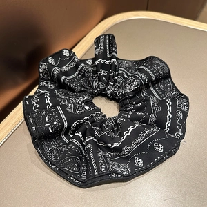 Macro shot of navy blue paisley print scrunchie with detailed woven fabric texture