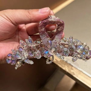 Gros plan de perles en cristal violettes et perles irisées sur une pince à cheveux en métal