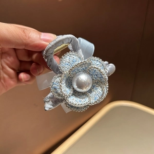 Detail of blue tweed camellia hair claw clip with large pearl and sparkling rhinestones