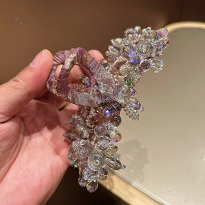 Détail de la pince à cheveux en soie violet champagne avec fleurs en cristal et perles