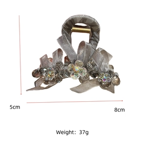 Detail view of the silver-grey mesh bow hair claw with crystals and sizing dimensions