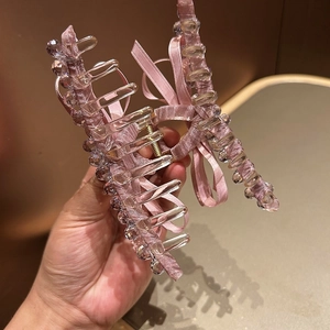 Detail of pink satin hair claw clip with crystal beads and elegant ribbon bow decoration