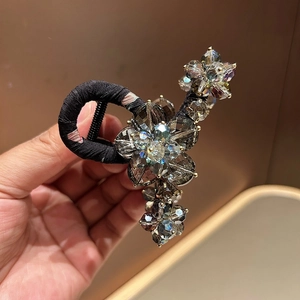Detailed close-up of a floral hair clip with faceted crystals and metallic base