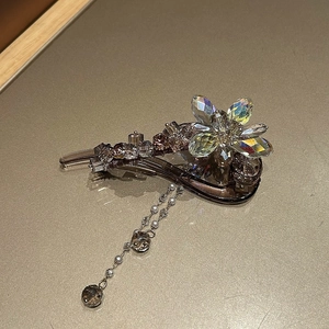Vue détaillée d'une barrette à fleurs en cristal avec d'élégants pompons suspendus