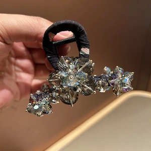 Detail of smoky crystal floral hair claw with a secure black metal grip for women
