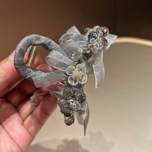 Elegant gold metal hair claw with grey mesh ribbon bow and crystal bead accents