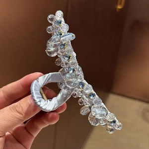 Dettaglio di un grande fermaglio per capelli con cristalli e finitura satinata