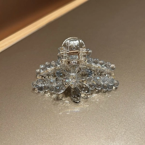 Détail macro d'une pince à cheveux fleurie en cristal avec des éléments en métal doré