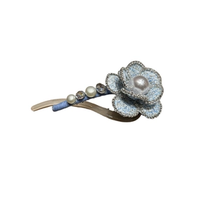 Blue tweed camellia hair clip with pearl center and rhinestone details on white background