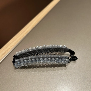 Detail of silk-wrapped crystal banana hair clip with anti-slip teeth and beads