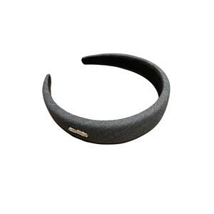 Elegant dark grey striped fabric headband with a small gold metal tag for women