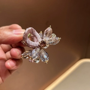 Close-up of pink fabric headband with crystal flower beads and purple gemstone detail