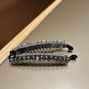 Detail showing double-row grey crystal beads and mesh fabric on Korean banana hair clip