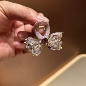 Detailed view of luxury butterfly hair claw with pink crystals and lilac fabric wrap
