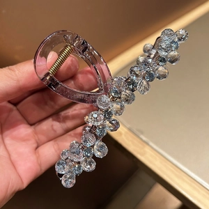 Close-up of large lavender crystal shark hair claw clip with gold metal spring