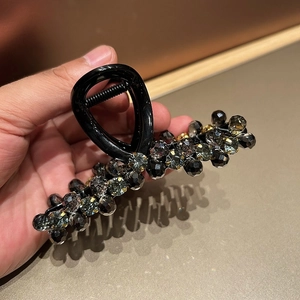 Close-up of handmade crystal beaded hair claw clip with dark grey faceted beads