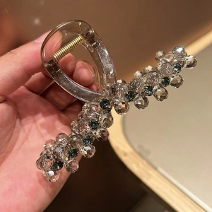 Detailed close-up of acrylic hair claw clip with faceted grey and clear crystal beads