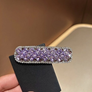 Makroaufnahme der rechteckigen Haarspange mit lila Kristallen und weißen Diamanten