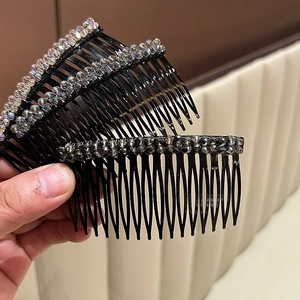 Dettaglio di un pettine per capelli con fiori di cristallo e perle scure eleganti