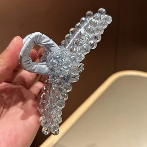 Primo piano di una grande molletta per capelli in raso azzurro con perline di cristallo