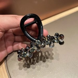 Detail of elegant black shark hair clip with gray faceted crystal bead embellishments