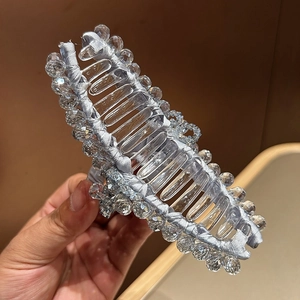 Vista dettagliata della grande clip per capelli con seta azzurra e perle di cristallo