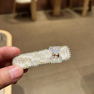 Eleganter Bären-Haarclip mit Kristallperlen und goldener Schleife auf rechteckiger Basis
