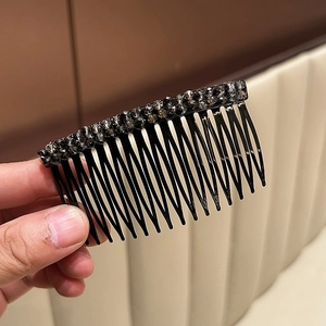 Dettaglio di un pettine per capelli in cristallo nero con eleganti strass a due file