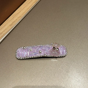 Detail einer lila Haarklammer mit Kristallen, Perlen und süßem Bären-Dekor