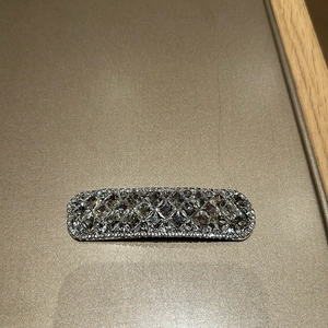 Detail einer minimalistischen Haarspange mit rechteckigem Design und klaren Kristallen
