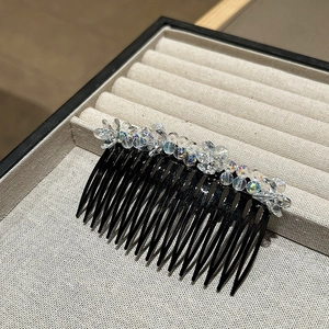 Detailed macro view of handmade colorful crystal bead flower hair comb on display tray