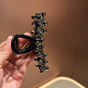 Detail view of crystal beaded hair claw clip with grey faceted stones and black base