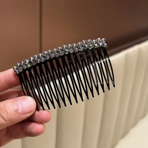Dettaglio ravvicinato di strass in cristallo a doppia fila su un pettine per capelli nero