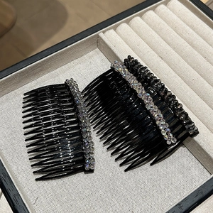 Dettaglio di tre pettini per capelli neri con strass lucidi in una scatola vellutata